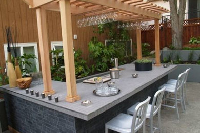 Diseño de patio actual grande en patio trasero con cocina exterior y cenador