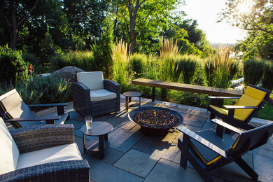 Foto de patio clásico renovado grande sin cubierta en patio trasero con adoquines de piedra natural y brasero