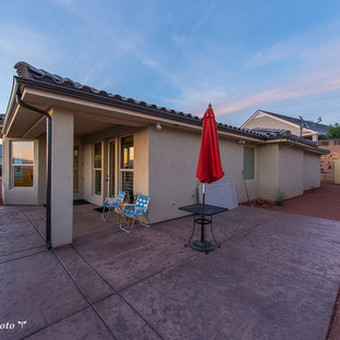 Immagine di un piccolo patio o portico stile americano dietro casa con cemento stampato e un tetto a sbalzo