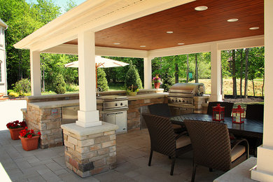 Example of a large trendy backyard concrete paver patio kitchen design in Cleveland with a gazebo