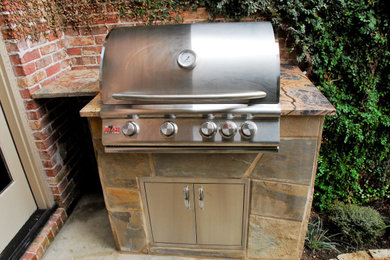 Patio kitchen - small traditional backyard stone patio kitchen idea in Dallas with no cover