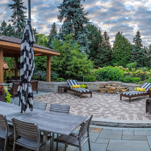 Esempio di un grande patio o portico tradizionale dietro casa con un gazebo o capanno e pavimentazioni in pietra naturale