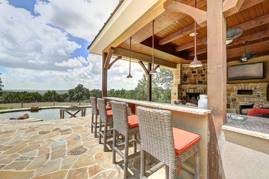 Example of a mountain style backyard patio kitchen design in Austin with a roof extension