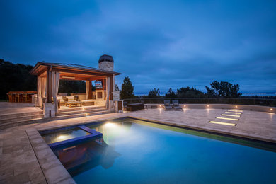 Imagen de piscina tradicional renovada extra grande con adoquines de piedra natural