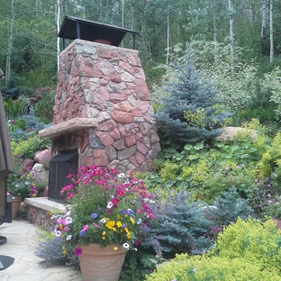Ispirazione per un patio o portico boho chic di medie dimensioni e dietro casa con un focolare, pavimentazioni in pietra naturale e nessuna copertura