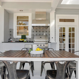 Foto di un grande patio o portico chic dietro casa con pedane e un tetto a sbalzo
