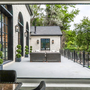 Immagine di un grande patio o portico mediterraneo dietro casa con lastre di cemento e nessuna copertura