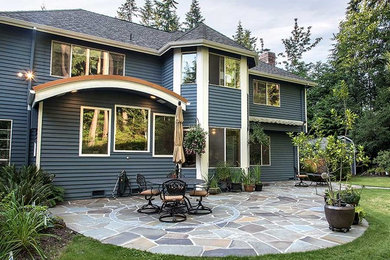 Patio - large traditional backyard stone patio idea in Seattle with no cover