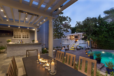 Klassische Pergola hinter dem Haus mit Outdoor-Küche und Natursteinplatten in Los Angeles