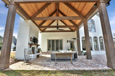 Example of a large classic backyard brick patio design in Atlanta with a fire pit and a roof extension