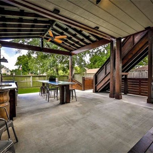Large urban backyard concrete patio kitchen photo in Houston with a roof extension