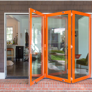 Immagine di un ampio patio o portico minimal dietro casa con lastre di cemento e un tetto a sbalzo