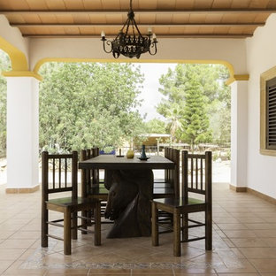 Imagen de patio mediterráneo con suelo de baldosas y pérgola