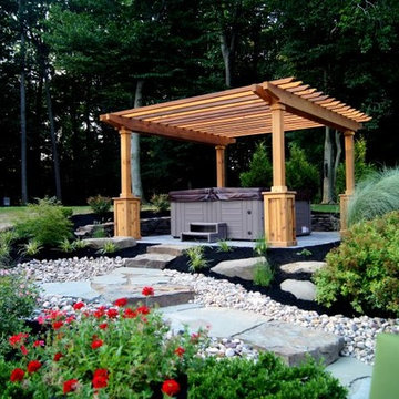 Hot Tub Placed in Natural Setting with Stone Steps and Pergola