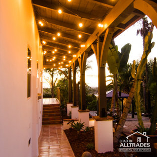 Ispirazione per un ampio patio o portico boho chic dietro casa con piastrelle e un tetto a sbalzo