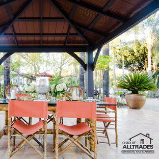 Immagine di un ampio patio o portico boho chic dietro casa con piastrelle e un gazebo o capanno