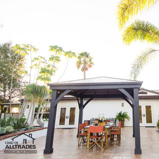 Immagine di un ampio patio o portico bohémian davanti casa con piastrelle e un gazebo o capanno