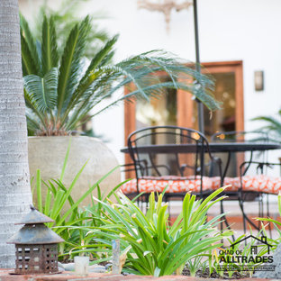 Idee per un ampio patio o portico eclettico dietro casa con piastrelle