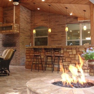 Houston covered patio with rustic fire pit, bar area