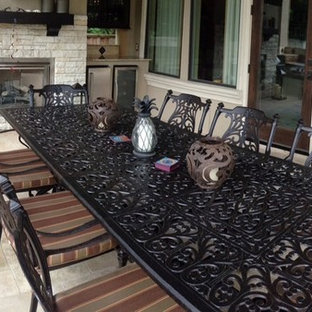 Ispirazione per un patio o portico mediterraneo di medie dimensioni e dietro casa con pavimentazioni in pietra naturale e un tetto a sbalzo