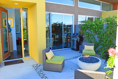 Patio - small contemporary courtyard concrete patio idea in Other with a fire pit and no cover