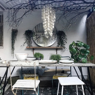 Small shabby-chic style patio in Gloucestershire with an awning.