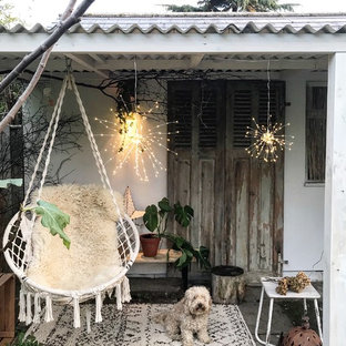Small shabby-chic style patio in Gloucestershire with concrete paving.