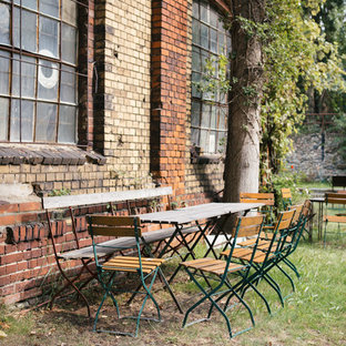 Example of a mid-sized urban side yard patio design in Berlin with no cover