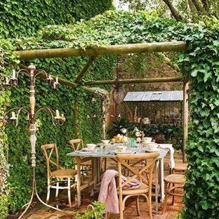 Esempio di un patio o portico rustico nel cortile laterale con pavimentazioni in mattoni e una pergola