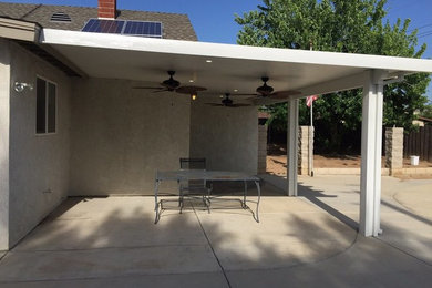 На фото: двор среднего размера на заднем дворе в стиле неоклассика (современная классика) с покрытием из бетонных плит и навесом