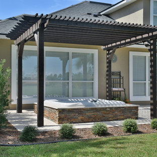 Inspiration for a mid-sized transitional backyard stone patio remodel in Jacksonville with a pergola