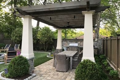 Inspiration for a small transitional backyard stone patio kitchen remodel in Atlanta with a pergola