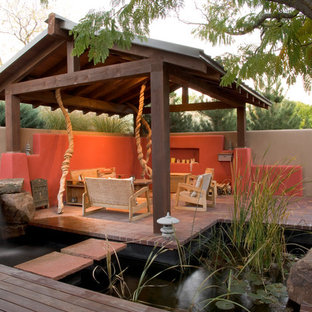 Idee per un patio o portico etnico in cortile con fontane, pavimentazioni in mattoni e una pergola
