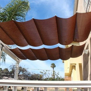 Mid-sized minimalist backyard patio photo in Orange County with an awning