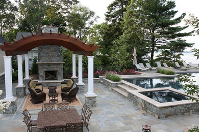 Inspiration for a huge timeless backyard stone patio remodel in Baltimore with a fire pit and a pergola