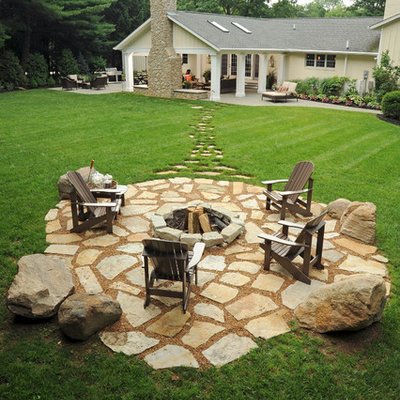 Inspiration for a large timeless backyard stone patio remodel in Columbus with a fire pit