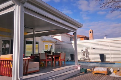 This is an example of a medium sized modern back patio in Melbourne with an outdoor kitchen, decking and a roof extension.