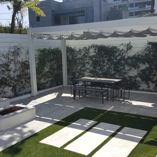 Esempio di un piccolo patio o portico minimalista dietro casa con un focolare, lastre di cemento e un gazebo o capanno