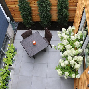 Esempio di un piccolo patio o portico contemporaneo dietro casa con piastrelle e nessuna copertura