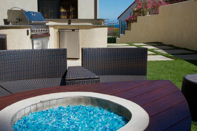 Example of a large trendy backyard concrete paver patio design in Los Angeles with a fire pit and no cover