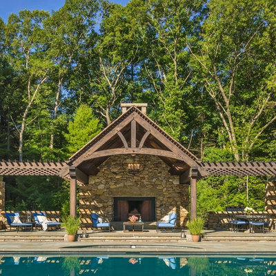Inspiration for a large rustic backyard concrete paver patio remodel in Boston with a pergola and a fireplace