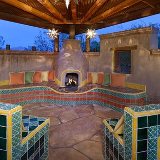 Esempio di un grande patio o portico boho chic in cortile con un focolare, pavimentazioni in cemento e un parasole
