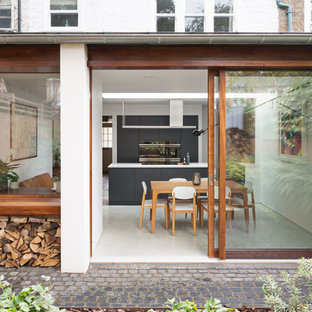 This is an example of a contemporary back patio in London with concrete paving and no cover.