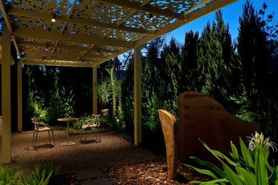 Example of a small trendy backyard gravel patio fountain design in Houston with a gazebo