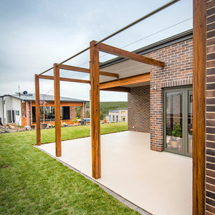 Immagine di un patio o portico minimalista di medie dimensioni e dietro casa con piastrelle e nessuna copertura
