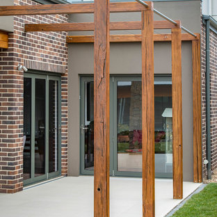 Foto di un patio o portico moderno di medie dimensioni e dietro casa con piastrelle e nessuna copertura