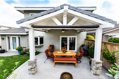 Inspiration for a mid-sized timeless backyard concrete patio kitchen remodel in Orange County with a roof extension
