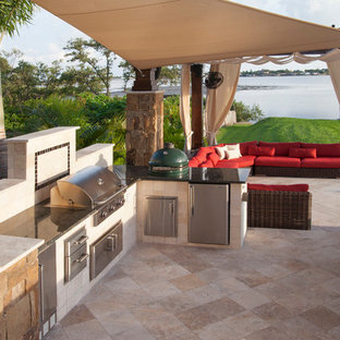 Immagine di un grande patio o portico contemporaneo dietro casa con pavimentazioni in pietra naturale e una pergola