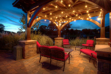 Inspiration for a large traditional back patio in Orange County with brick paving and a gazebo.