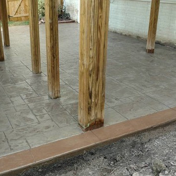 J-Stamped concrete patio with a step under the wood deck